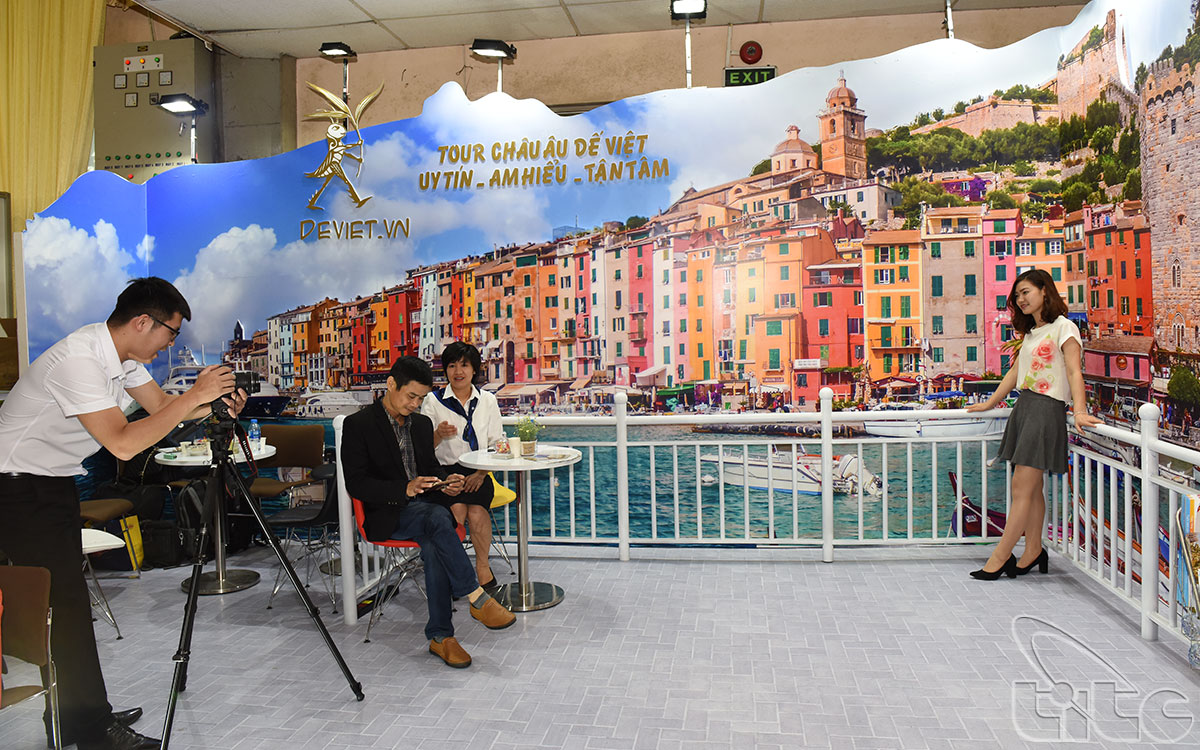 Visitors have exciting experience with  the photos of European tourism at the booth of De Viet Travel