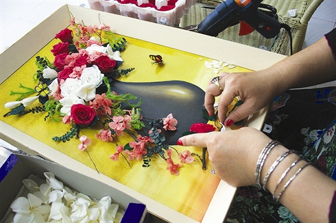À Hô Chi Minh-Ville, une femme qui dessine avec des fleurs fraîches